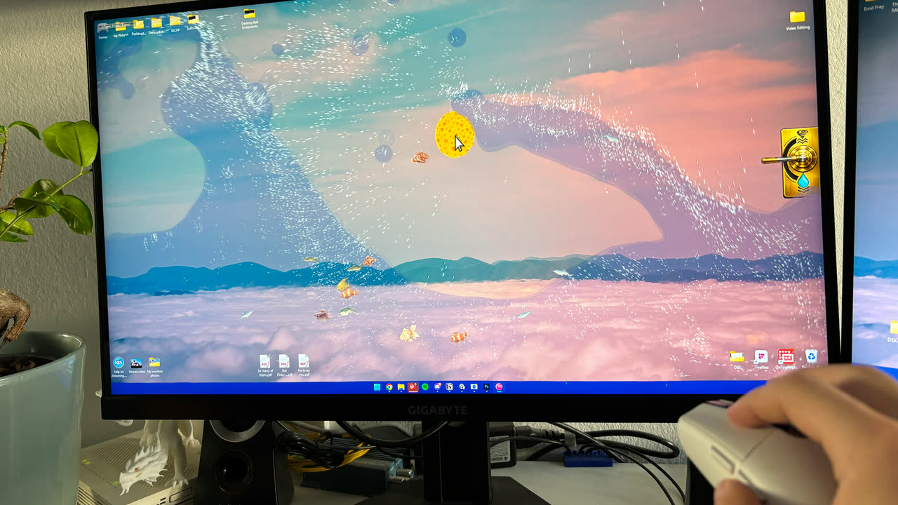 Water pooled along the bottom edge of a monitor with fish swimming in it, the Spongeball soaking at the surface over an open article.